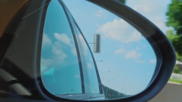 Right side rear view mirror of car driving from day light to dark tunnel. Automobile mirror reflecting blue sky, clouds and lamp posts, tunnel lights in dusk on highway. Reflections. Sitter or passenger perspective inside of car. Vacation concept - Footage, Video