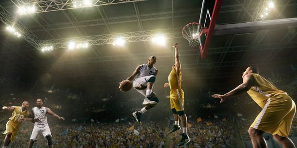 Jugadores de baloncesto en la gran arena profesional durante el juego. Jugador de baloncesto hace slum dunk
 - Foto, Imagen