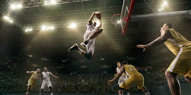 Basketbal spelers op de grote professionele Arena tijdens het spel. Basketballer maakt sloppenwijk dunk - Foto, afbeelding