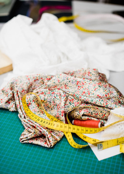 Herramientas, patrones y muestras de tela en la mesa de coser en el taller de sastrería
 - Foto, Imagen