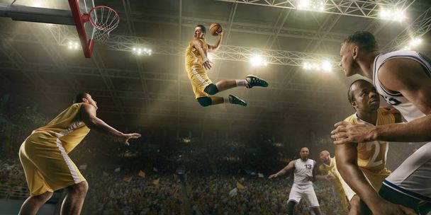 Basketball players on big professional arena during the game. Basketball player makes slum dunk - Photo, Image