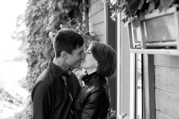 家の近くで恋に落ちたカップル。男と女のキス, bw - 写真・画像