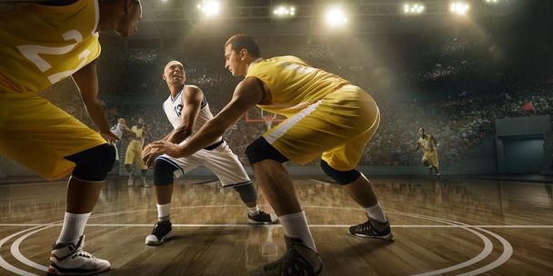 Koszykarze na dużej profesjonalnej arenie podczas gry. Mężczyźni koszykarze walczą o piłkę - Zdjęcie, obraz