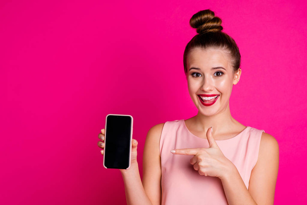 Portrait of cute pretty lovely sweet millennial hold hand modern technology promote ads choose decide wear blouse she her top knot red lipstick lips stick pomade isolated pink background - Fotoğraf, Görsel