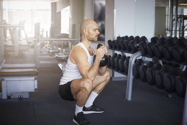 Shot of man in the gym doing dumbbell exercises - Фото, изображение
