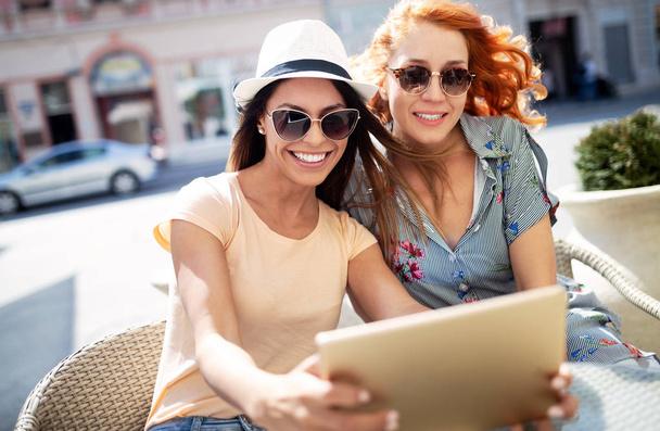 Beautiful girls women having fun smiling together in a cafe outdoor - 写真・画像