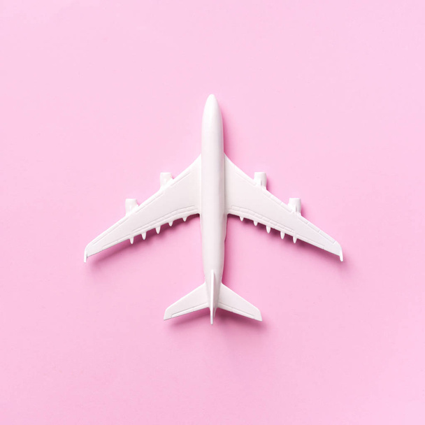 Viaggio, concetto di vacanza. Aereo modello bianco su sfondo di colore rosa pastello con spazio copia. Vista dall'alto. Piatto. Design in stile minimale. Coltivazione quadrata
 - Foto, immagini