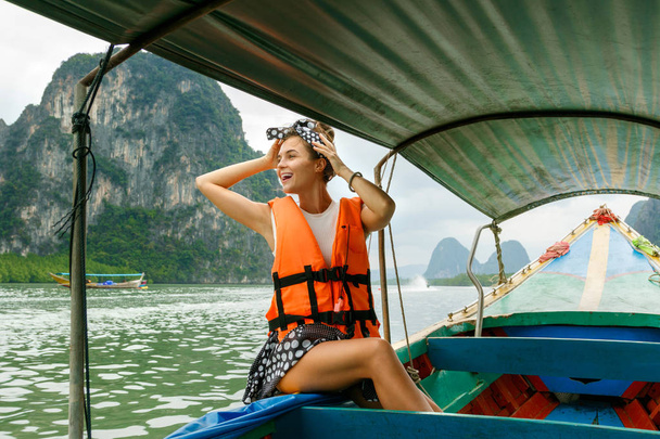Young woman on the long-tail boat during her vacations in Thaila - Photo, Image