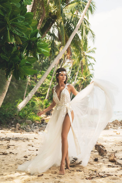 Sensual bride wearing beautiful wedding dress on the tropical is - Фото, зображення