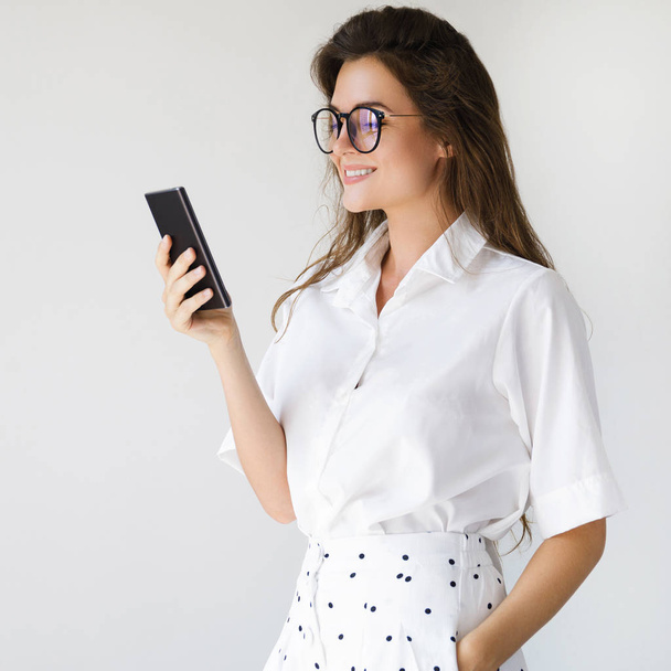 Young businesswoman is using smartphone - Foto, afbeelding