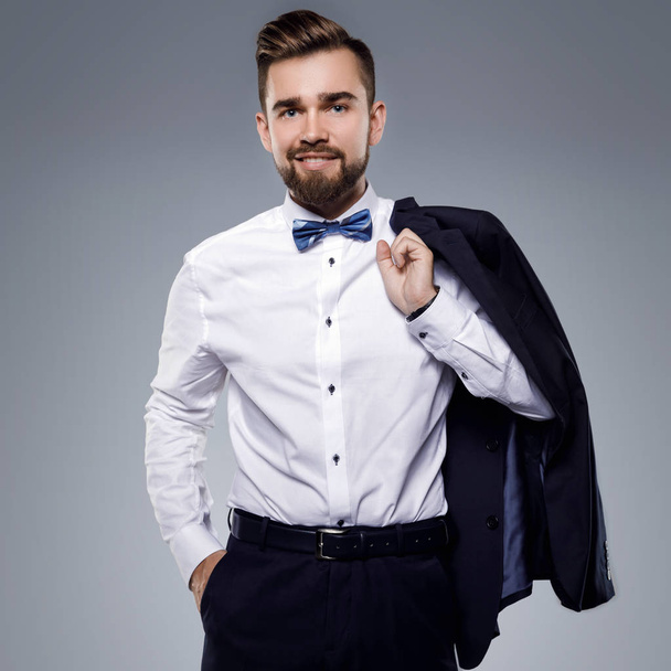 Stylish handsome man wearing a classic suit with bow-tie - Fotó, kép