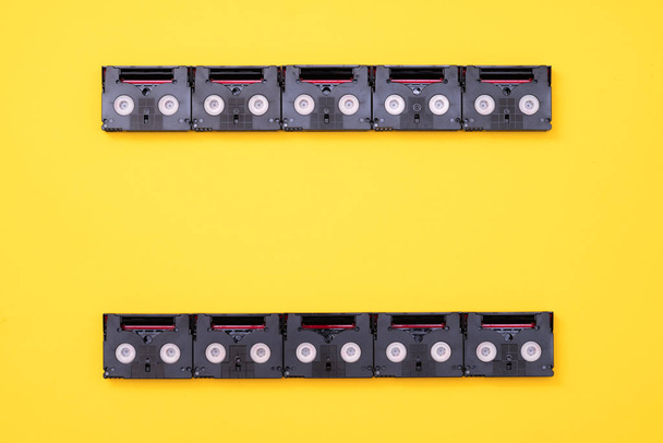 Analog film ekran konsepti bir gün içinde geri filme kullanılan vintage mini Dv kasetler yapılmış. Sarı arka plan üzerinde plastik video bantları yapılmış desen - Fotoğraf, Görsel