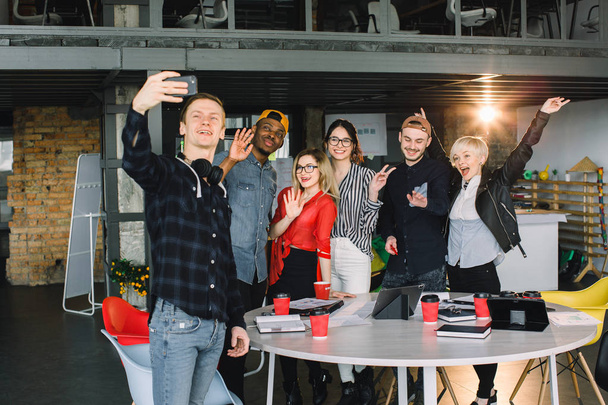 Positive group of business people making selfie in modern office. Group of six hipster workers making selfie after meeting - Photo, Image