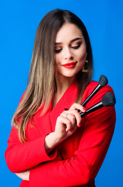 Sexy woman with professional makeup brush tool. Fashion portrait of woman. jewelry earrings. Girl in red jacket. beauty and fashion. hair beauty and hairdresser salon. Hair like fire - Foto, Imagen