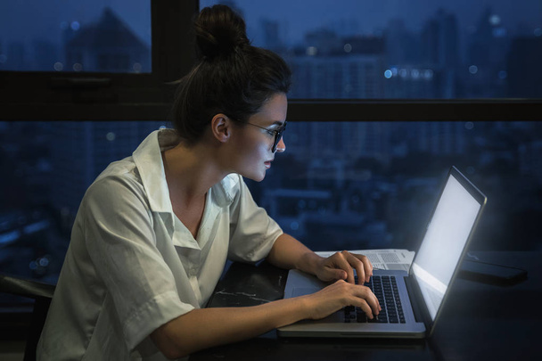 Woman is working with laptop at home during night. - Fotografie, Obrázek