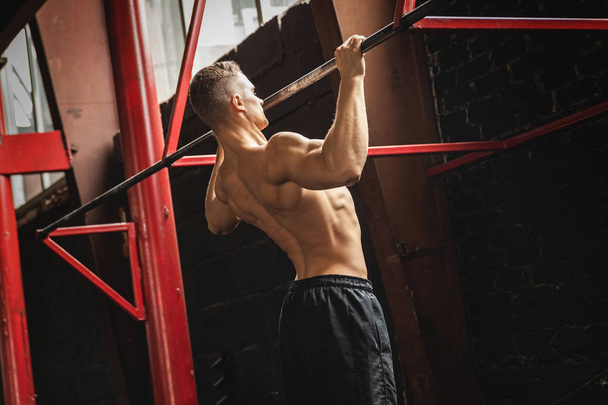 Strong man doing pull up exercise in the gym - Fotografie, Obrázek
