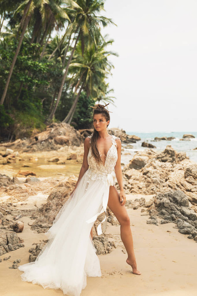 Bride wearing beautiful wedding dress on the tropical beach - Foto, afbeelding
