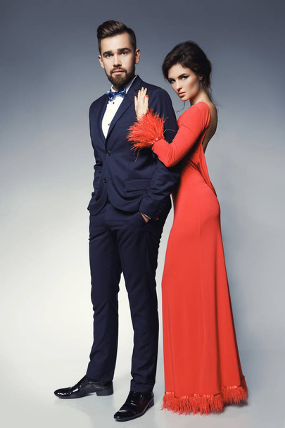 Woman in beautiful red dress and man wearing blue classical suit - Fotó, kép