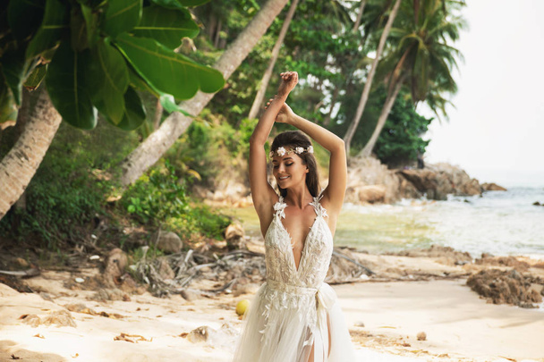 Sensual bride wearing beautiful wedding dress on the tropical is - Foto, immagini