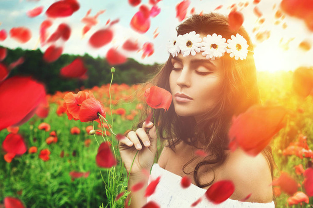 Beautiful woman in field with a lot of poppy flowers - Photo, Image