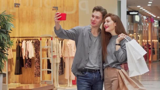 Szép fiatal pár figyelembe selfies vásárlás közben a plázában együtt - Felvétel, videó