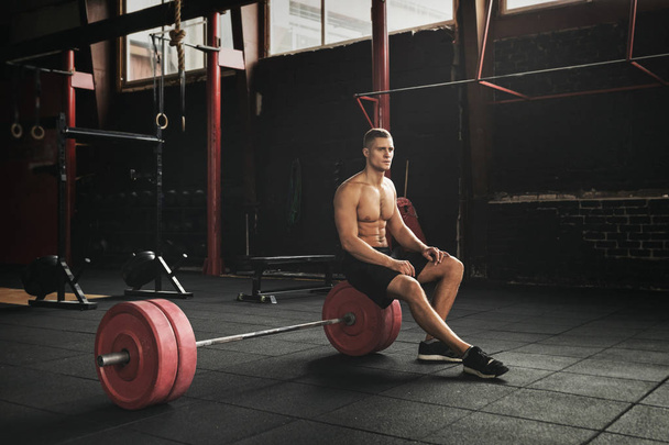 Muscular young man resting between sets - Fotografie, Obrázek