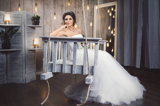 junge glückliche Braut trägt schöne üppige Kleid im Zimmer mit  - Foto, Bild