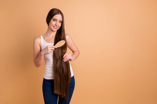 Close up photo beautiful amazing her she lady hold arms hands very long brown hair great condition curls hair brush carefully wear casual white tank-top jeans denim isolated pastel beige background. - Fotoğraf, Görsel