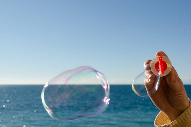 spelen van zeepbellen en blauwe lucht - Foto, afbeelding