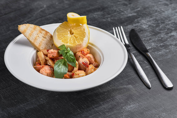 pasta with shrimp and fish on a dark background. Restaurant, food menu, recipe, cafe concept. - Photo, Image