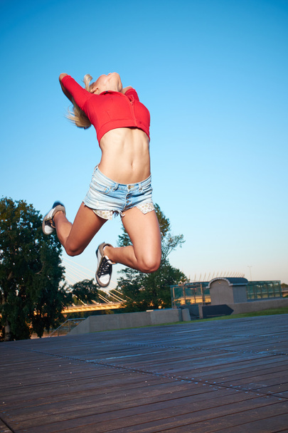 Athlete celebrating jumping and leaping against a night city. - Foto, Bild