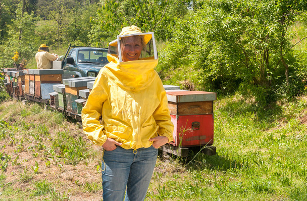 Retrato de mujer sonriente con sombrero de apicultura y velo en el jardín
. - Foto, imagen