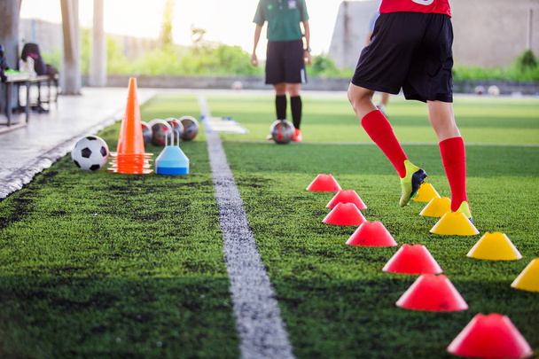 Soccer player Jogging and jump between cone markers on green art - Foto, immagini