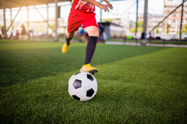 Jugador de fútbol carrera de velocidad para disparar pelota a gol en césped artificial
 - Foto, Imagen