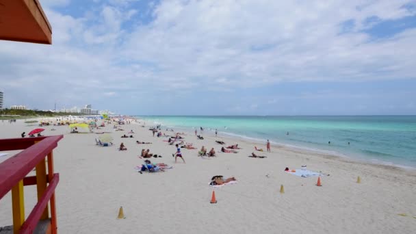 panoramic view of sandy beach with resting people - Filmati, video