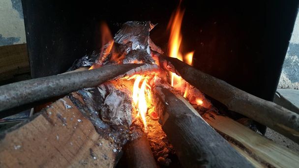 Fire on logs in fire pot with embers and burning coal and blazing flames. - Photo, Image
