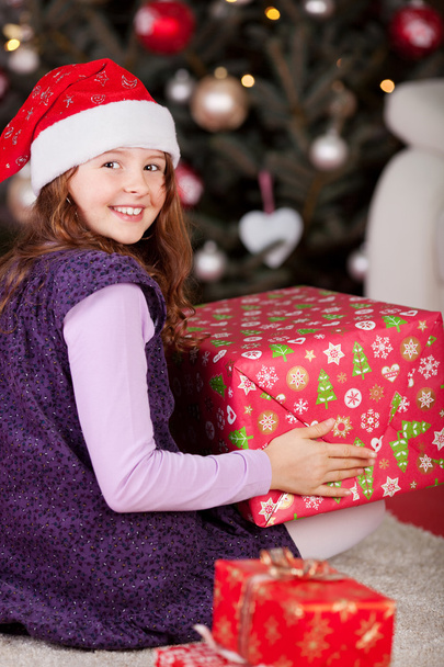 Joyful girl with a large red Christmas gift - Foto, afbeelding