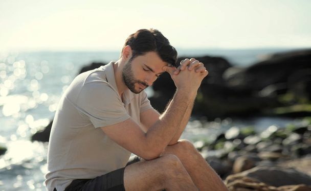 Один печальный человек, сидящий на пляже
 - Фото, изображение