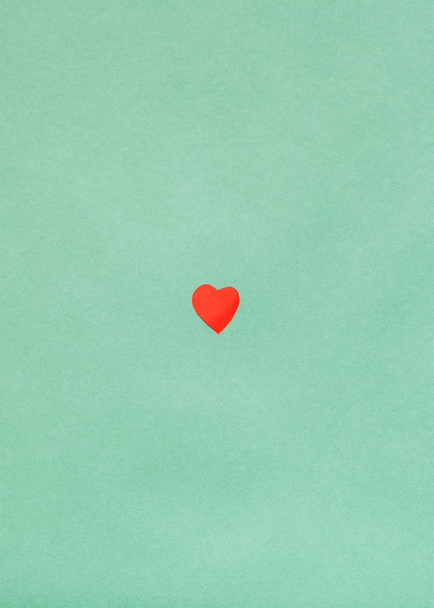 papel rojo corazón cortado sobre papel verde mar oscuro
 - Foto, Imagen