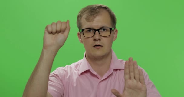Verlegen jonge man in shirt zwaaiende zijn handen en proberen om aandacht te besteden aan hem - Video