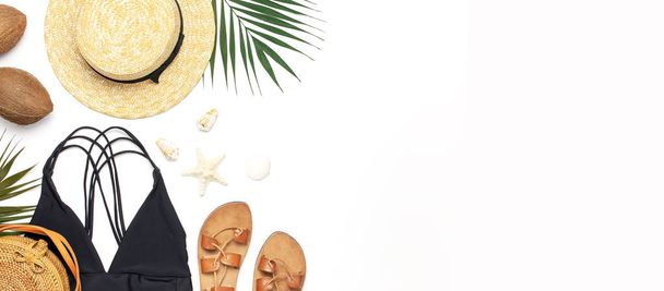 Acessórios de praia da mulher flat lay. Round trendy rattan bag straw hat black swimsuit leather sandals tropical palm leaves coconut seashells on white background. Espaço de cópia da vista superior. Fundo de verão
 - Foto, Imagem