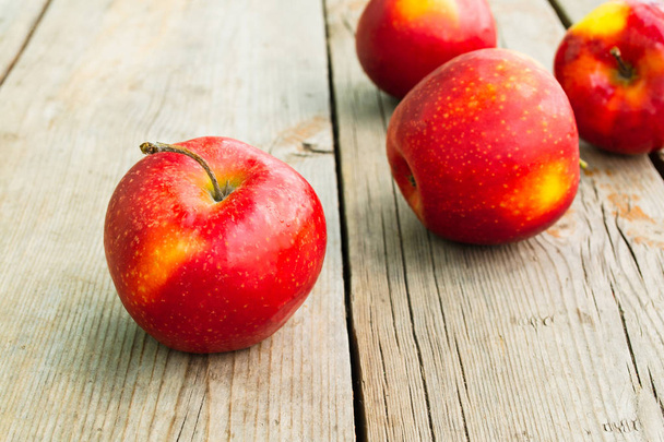Спелые красные яблоки на деревянном столе. Сельский стиль, крупный план
 - Фото, изображение
