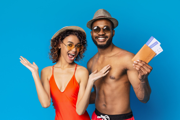 Happy african couple in swimsuits ready to chill out with tickets to resort - Zdjęcie, obraz