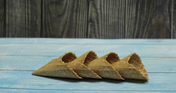 Ice cream cones, isolated on blue wooden surface. Waffles for ice cream - Footage, Video