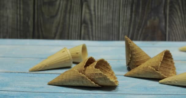Ice cream cones, isolated on blue wooden surface. Waffles for ice cream - Footage, Video