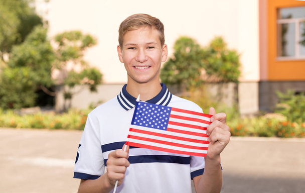 Uczeń nastolatek z flagą Stanów Zjednoczonych Ameryki. Studia za granicą. - Zdjęcie, obraz