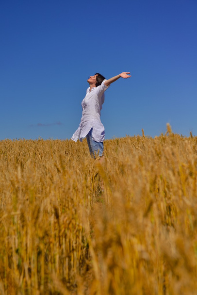 Jonge vrouw in tarweveld in de zomer - Foto, afbeelding