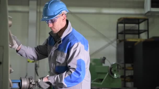 Kaukaska obróbka metali tokarek operator w jego 30s podczas przetwarzania materiału maszynowego. Materiał filmowy 4K z niewielkim ruchem - Materiał filmowy, wideo