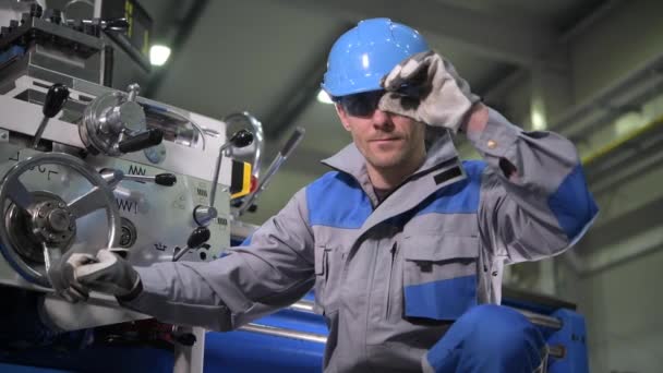 Μεταλλουργικοί φορείς ο τόρνος στα 30 του. Προστατευτικά γυαλιά και κράνος εργασίας - Πλάνα, βίντεο
