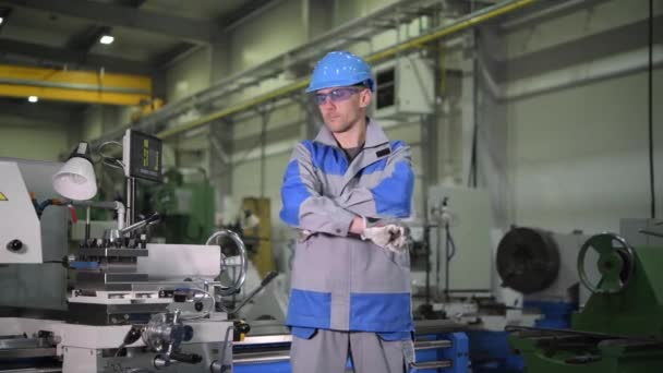 Zadowolony kaukaski Productionline pracownik przed metalową maszyną Tokarka - Materiał filmowy, wideo